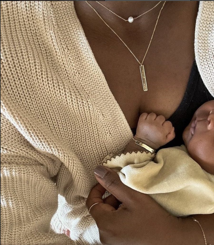 Mom wearing a necklace while holding her baby
