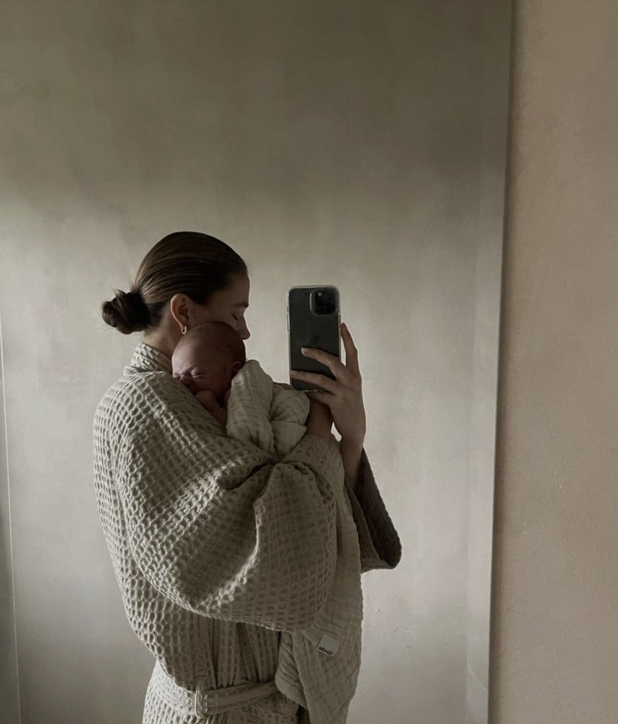 Mom taking a mirror selfie with her newborn
